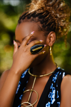 Model wearing an almond shaped black cow horn statement gold ring 