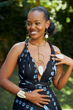 Model wearing an almond shaped white cow horn statement gold ring, matching cuff bracelet and matching neckpiece