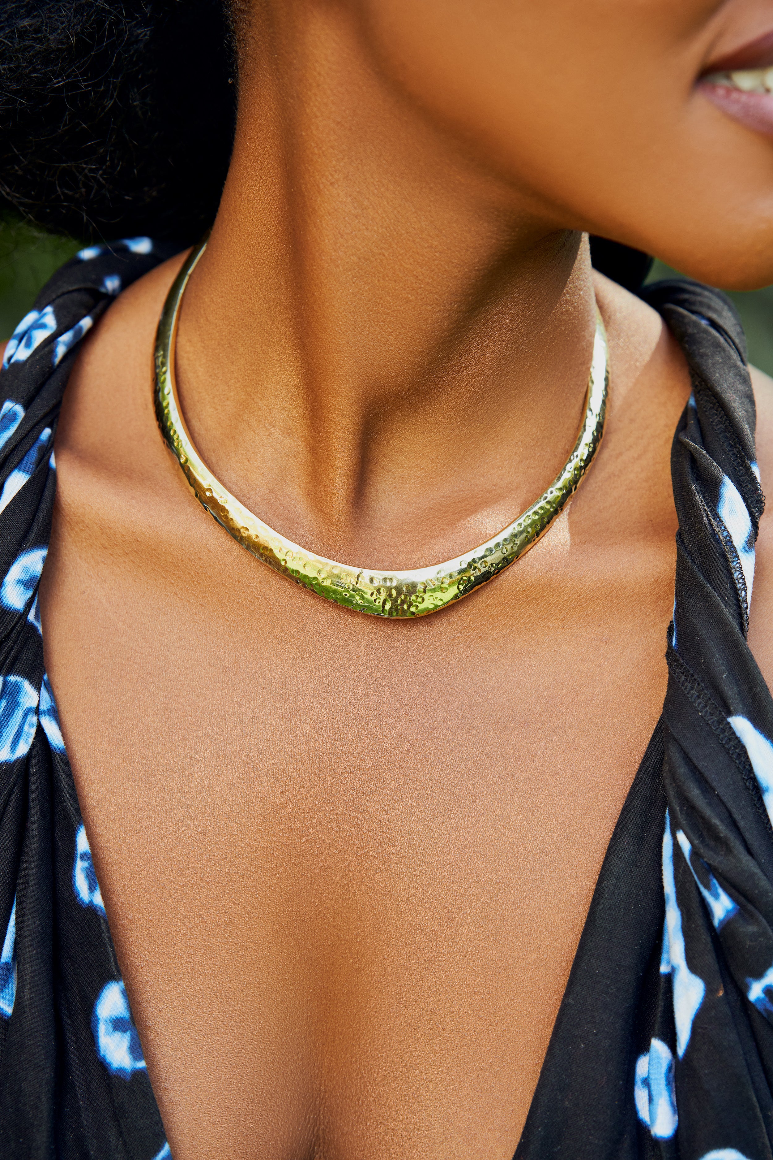 Close-up of a model wearing a gold choker