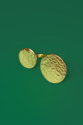 a gold ring with two flat disc shaped ends. One end is a larger circle. The top surface has a hammered finish. 