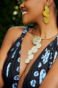 Model wearing a pair of gold cascading circular earrings and a matching choker with gold cascading circles  pendant