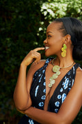 Model wearing a pair of gold cascading circular earrings and a matching choker with gold cascading circles  pendant