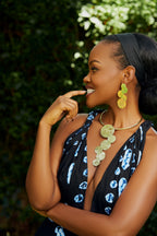 Model wearing a pair of gold cascading circular earrings and a matching choker with gold cascading circles  pendant