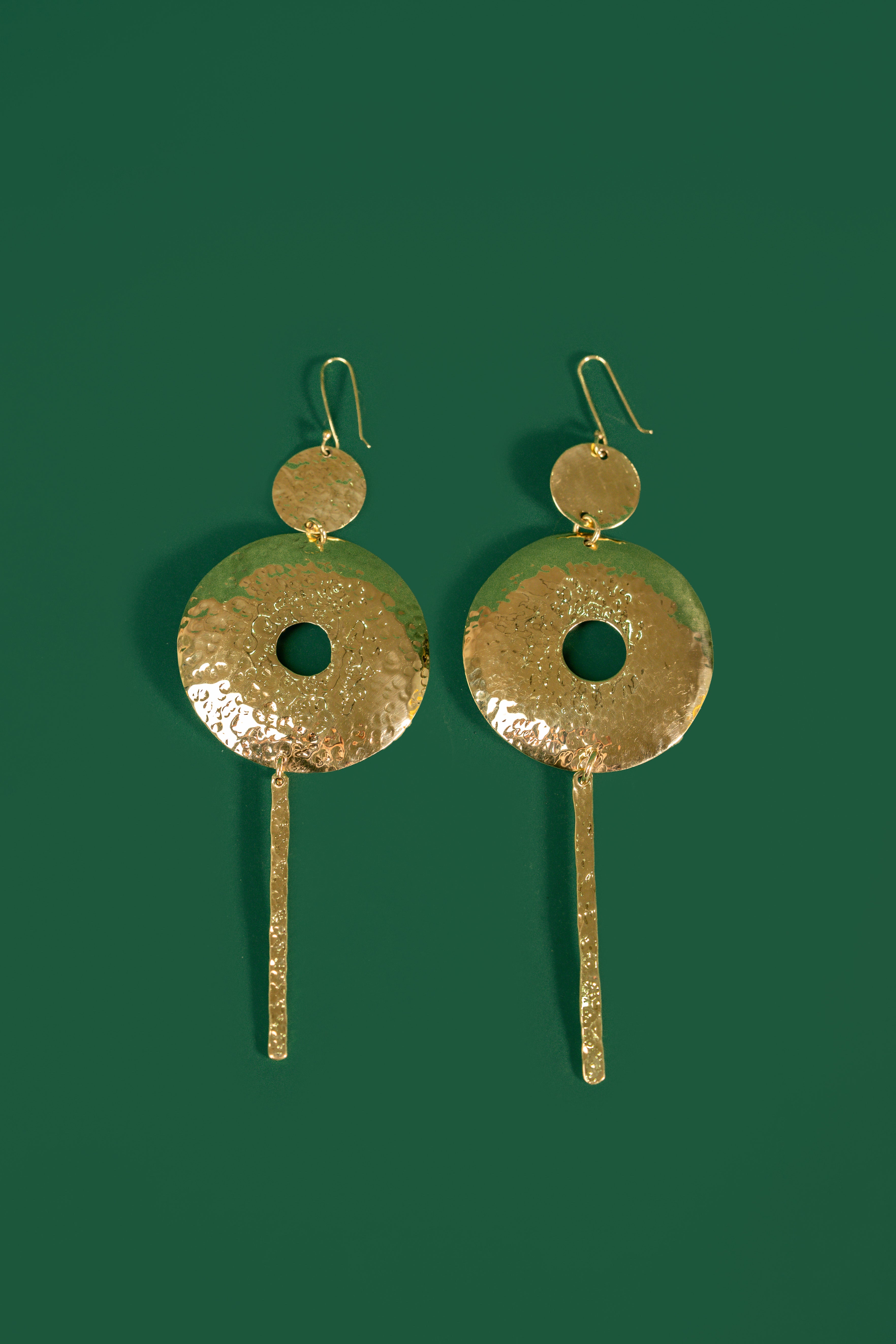 model wearing gold hoop earrings with a bar column pendant 