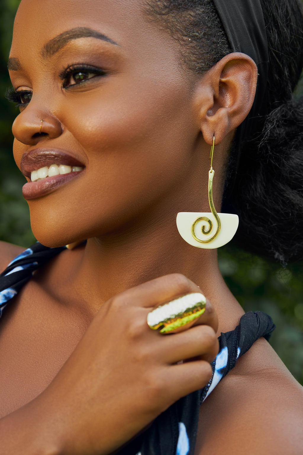 model wearing gold and white spiral drop earrings 