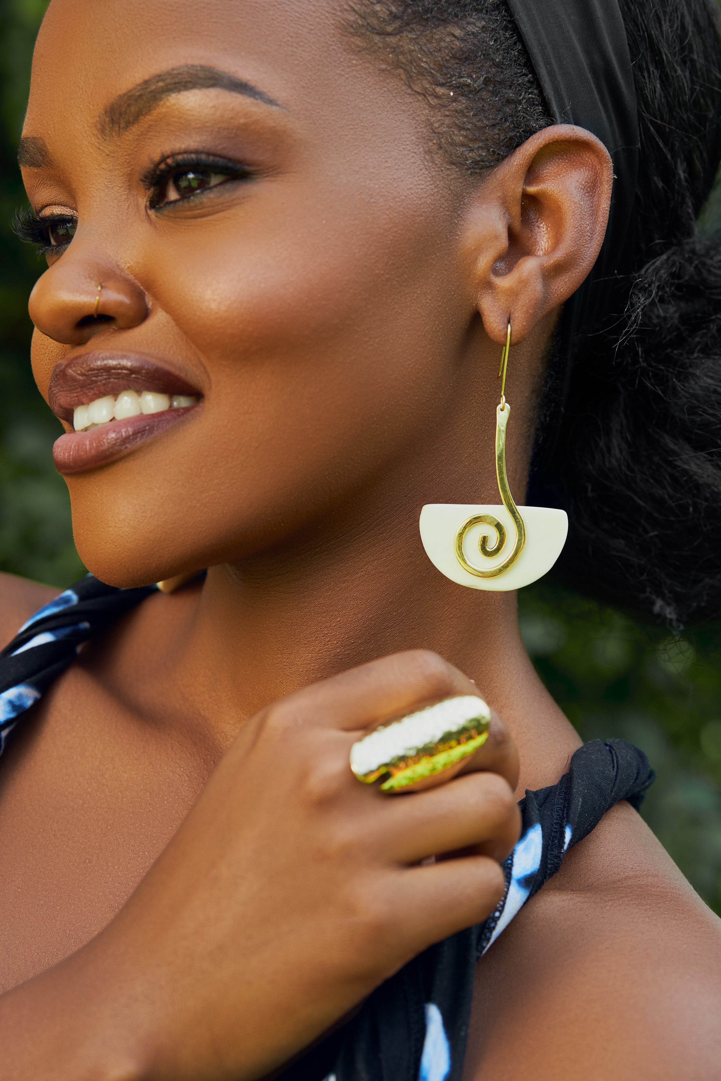 model wearing gold and white spiral drop earrings 