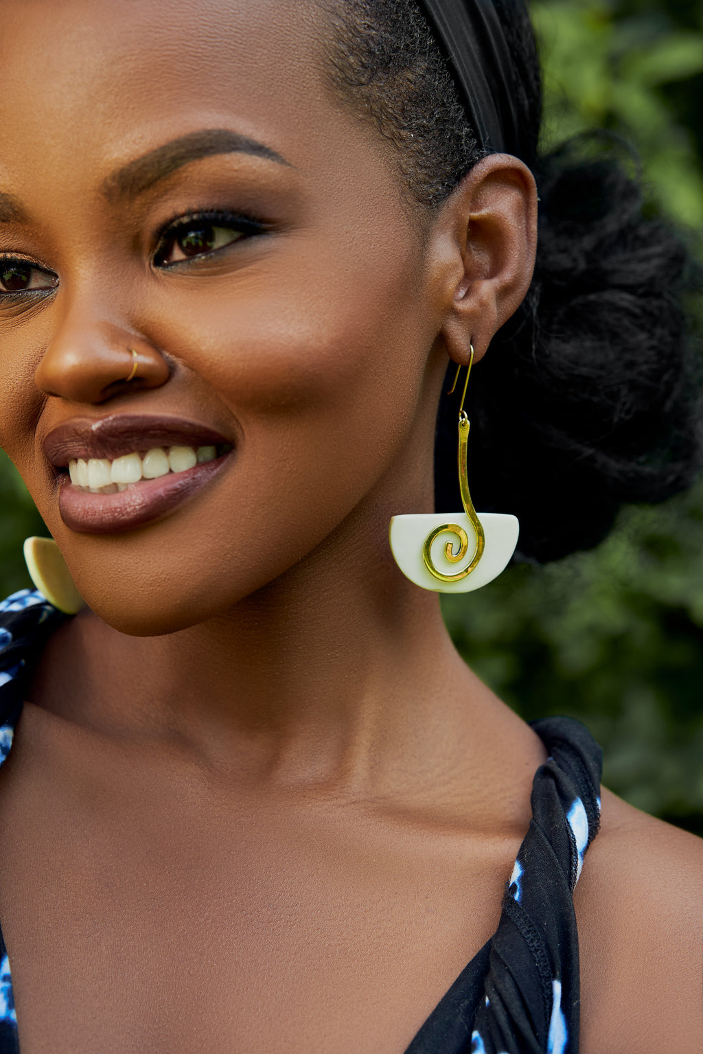 model wearing gold and white spiral drop earrings 