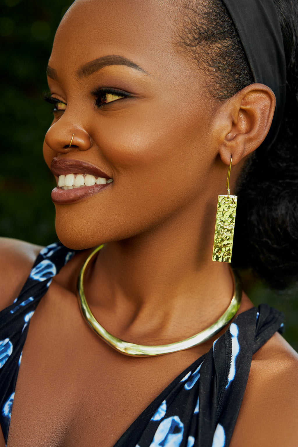 Model wearing gold rectangular earrings and a gold choker 