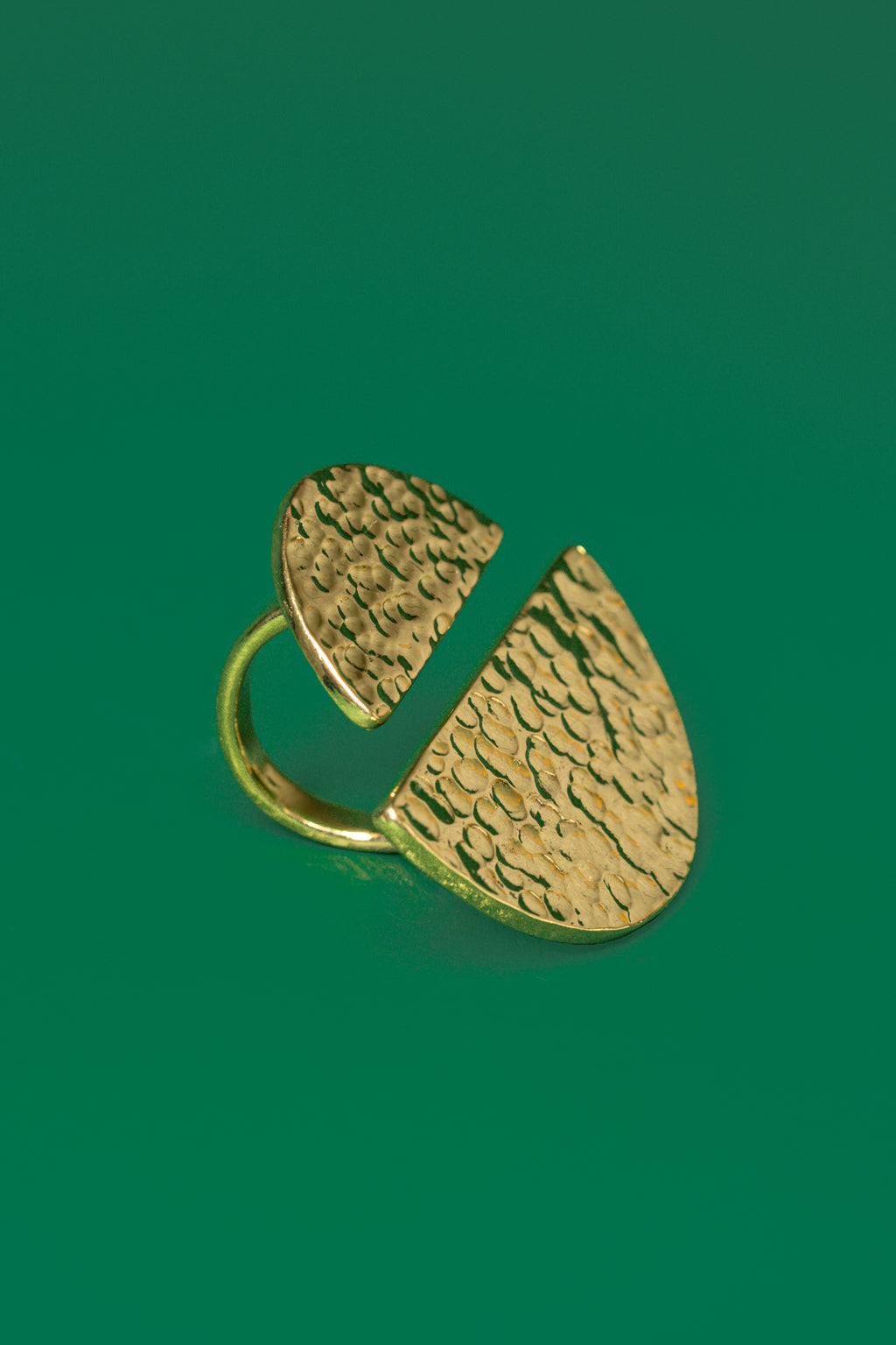 Gold ring with two unequal sized semi circular discs on both ends of the band