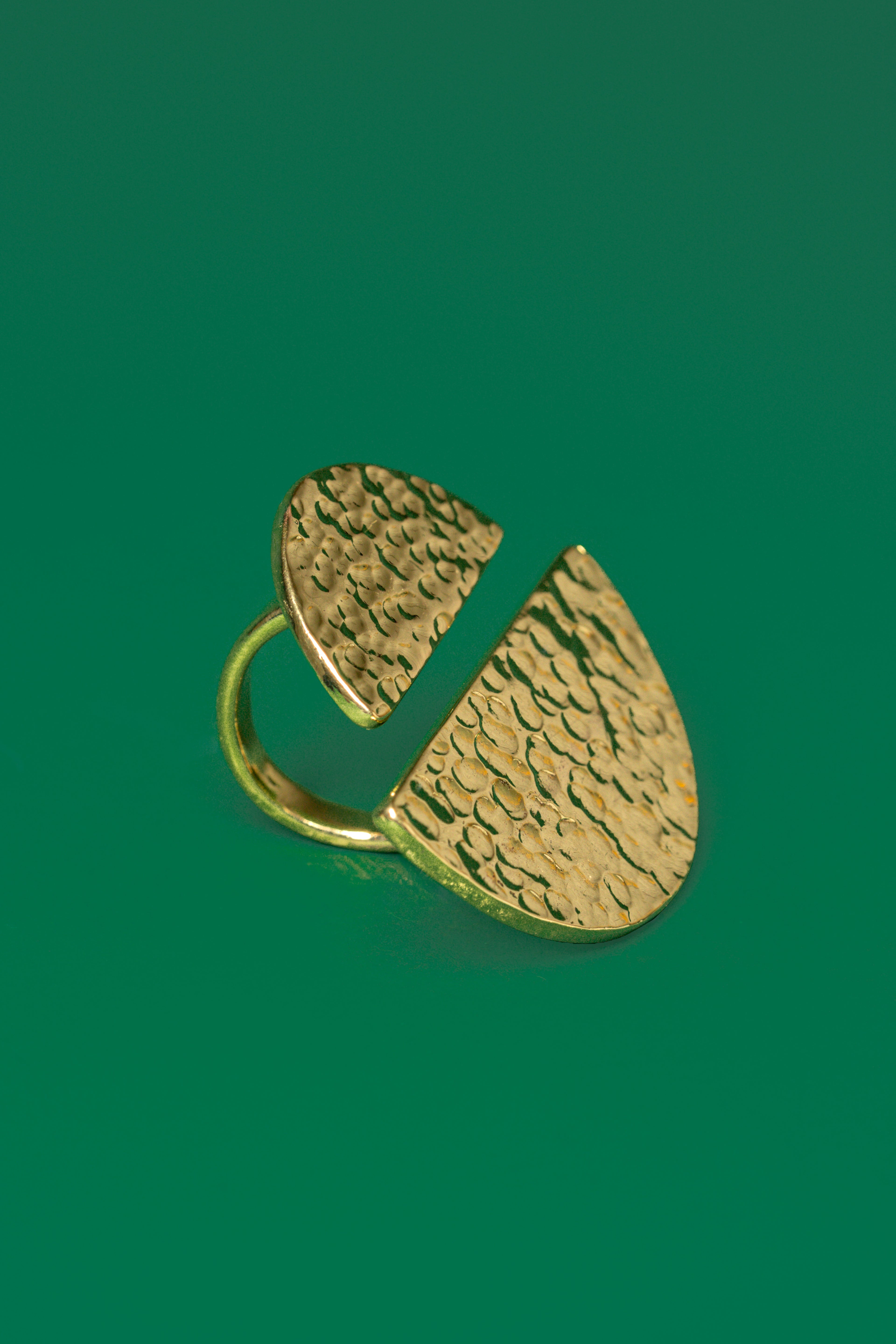 Gold ring with two unequal sized semi circular discs on both ends of the band