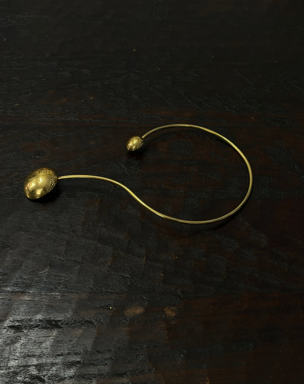 Gold necklace with spherical pendants on a dark textured surface