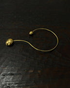 Gold necklace with spherical pendants on a dark textured surface