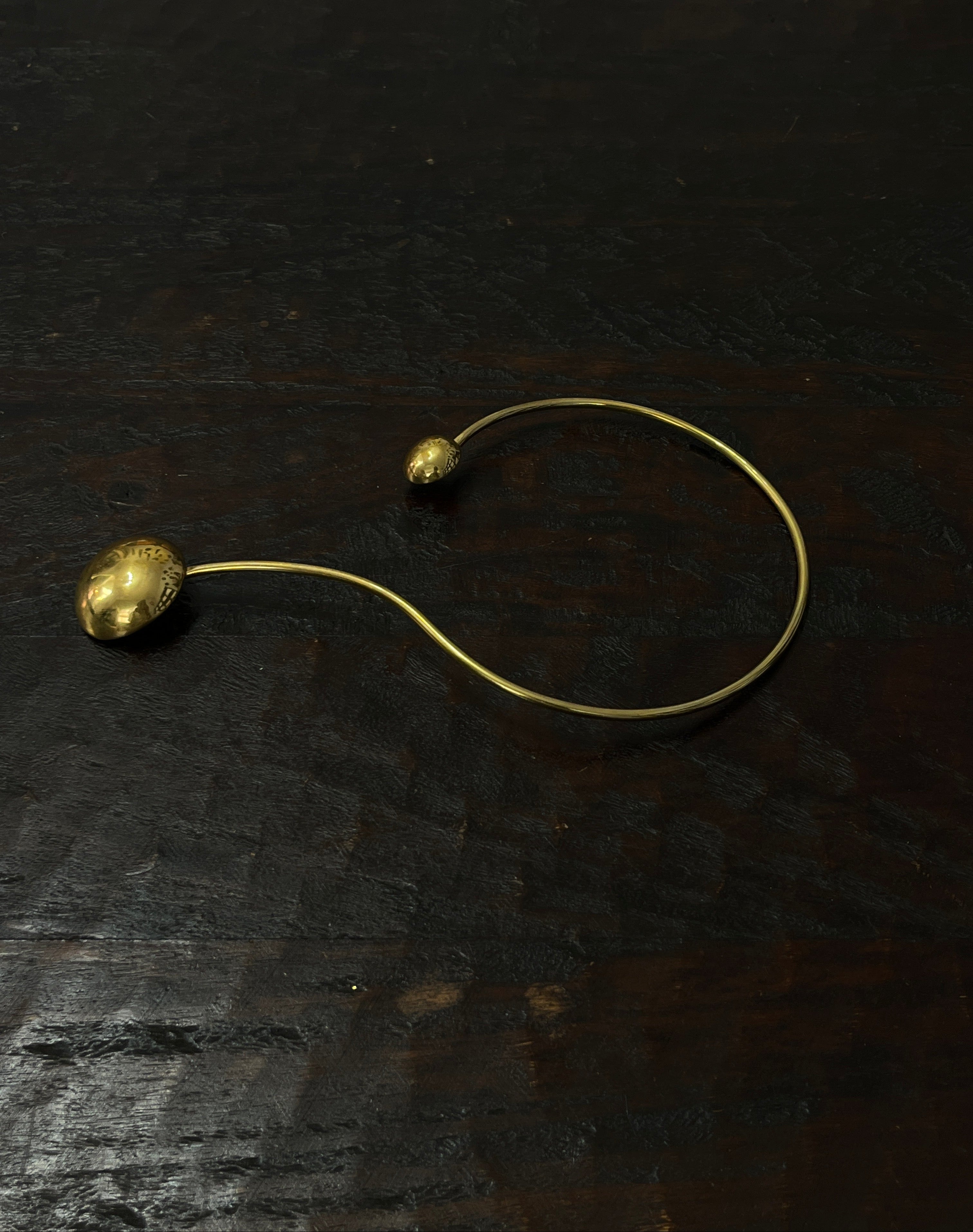 Gold necklace with spherical pendants on a dark textured surface