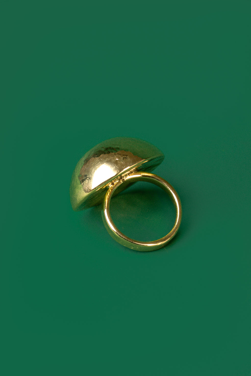 A gold spherical dome-shaped hammered ring 