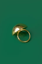 A gold spherical dome-shaped hammered ring 