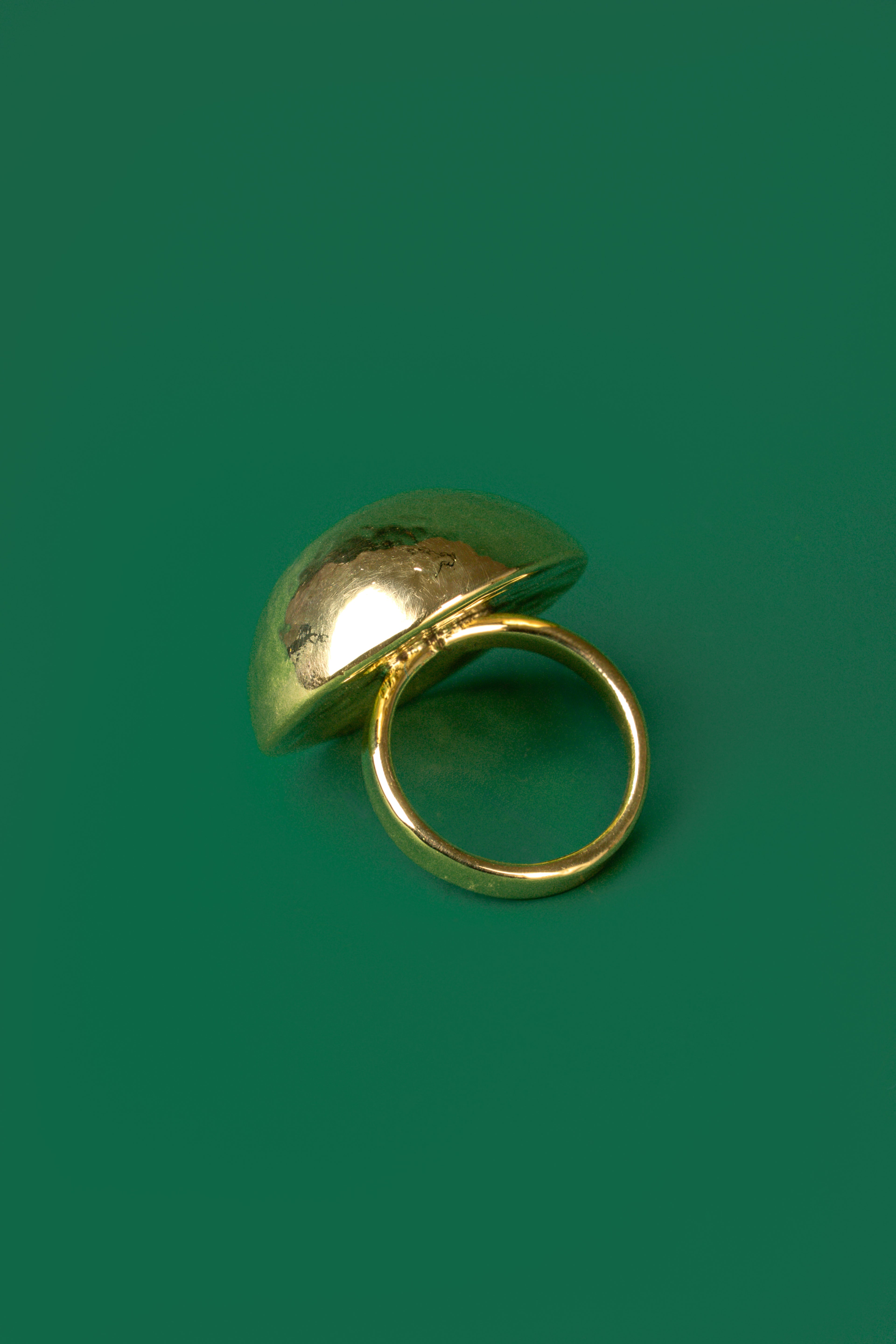 A gold spherical dome-shaped hammered ring 