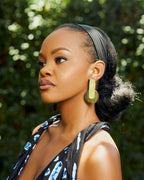 Model wearing gold rectangular with a brown circle pendant earrings