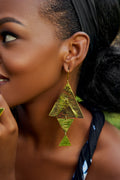 Close-up of a model wearing large, gold, triangular dangle earrings